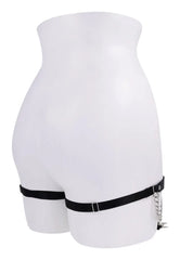 Rear view of black thigh garters on mannequin showing elastic band and adjustable back closure