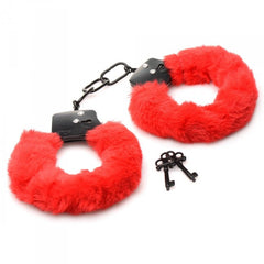 Close-up of red plush fur handcuffs with black metal locking mechanism and two keys