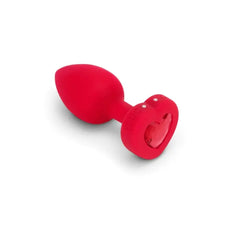 Close-up of red silicone anal plug showing heart-shaped scarlet ruby jewel base detail