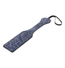 Reverse side of the studded paddle highlighting blue-grey leopard-print texture and slim handle