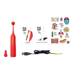 Romp Pop contents laid flat: device, spare tip, USB cable, booklets, and sticker sheet