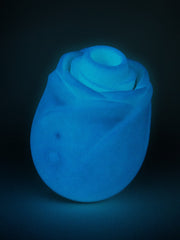 ROMP Rose Glow clitoral stimulator glowing blue in the dark showcasing glow-in-the-dark silicone