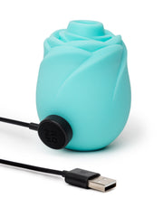 ROMP Rose Glow teal stimulator with magnetic USB charging cable attached to side port