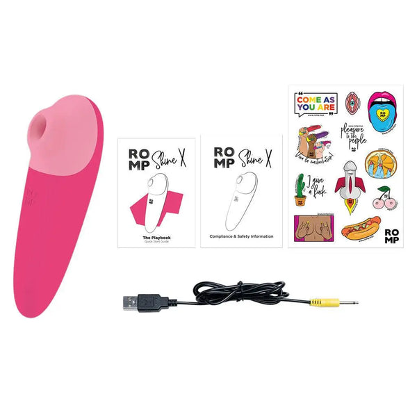 Romp Shine X stimulator shown with USB charging cable, user guides, and sticker sheet