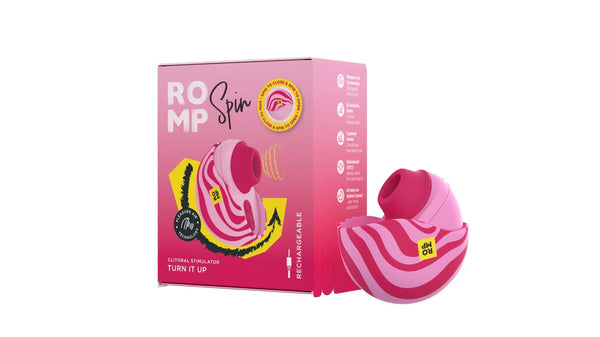 ROMP Spin clitoral stimulator beside its pink retail box, open to reveal nozzle