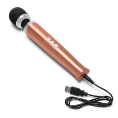 Rose gold Le Wand massager connected to USB charging cable showing the bottom charging port