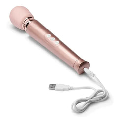 Rose gold Le Wand Petite Massager connected to white USB charging cable