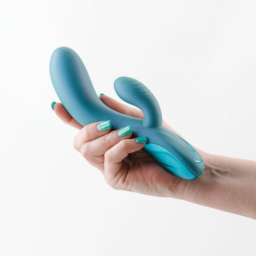 Royals Regent rabbit vibrator in metallic teal held in a hand, showing dual-arm silicone design