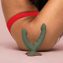 Sage green Ryde dildo with suction base shown in seated lifestyle context, scale reference