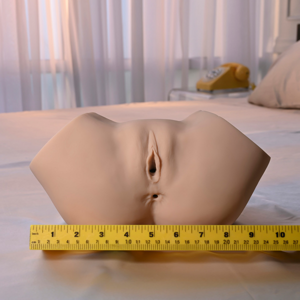 Sasha Grey Squirting Stroker measured against a tape rule on a bed, showing approximately 8 inches in width