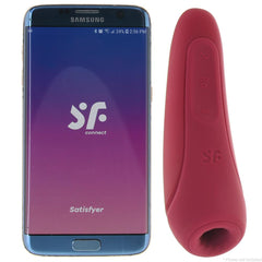 Satisfyer Curvy 1+ air pulse stimulator in rose red beside a Samsung phone showing the SF Connect app