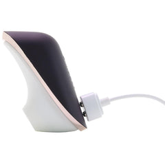 Satisfyer Pro Traveler connected to white magnetic USB charging cable, showing side profile and charging port