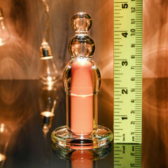 Scale view of plug beside ruler showing approximately 4.5 inches total height on reflective surface
