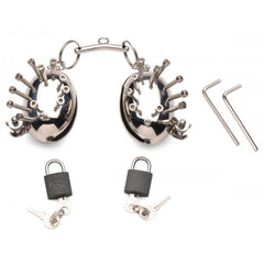 Scrotum Egg Shells with Spikes laid flat showing two cuffs, padlocks, keys, and hex wrenches