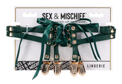 Sex & Mischief Indica Laced Up Garters in emerald green with gold-tone clips on packaging