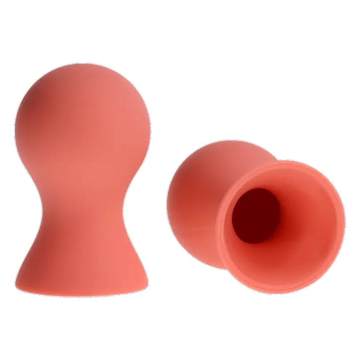 Sex & Mischief silicone nipple suckers in peach, shown upright and tipped to reveal hollow suction cup interior