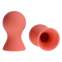 Sex & Mischief silicone nipple suckers in peach, shown upright and tipped to reveal hollow suction cup interior