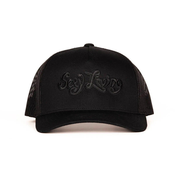 Sexy Living black trucker cap, front view showing tonal embroidered script logo on structured panel