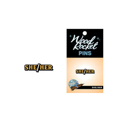 She/Her pronoun pin shown beside its Wood Rocket branded black and gold retail card