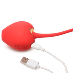 Shegasm red silicone stimulator connected to white USB magnetic charging cable, close-up view