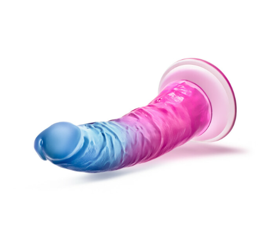 Side-angle view of gradient blue-to-pink dildo with suction cup base attached to surface
