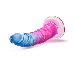 Side-angle view of gradient blue-to-pink dildo with suction cup base attached to surface