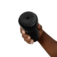 Side angle of Kiiroo Feel Pocket Stroker gripped in hand, black cylindrical body with soft cap