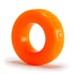 Close-up side angle of orange Oxballs silicone cock ring showing smooth flexible texture