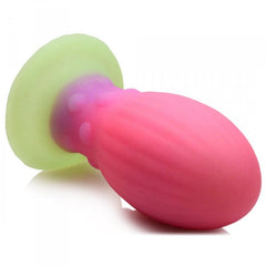 Side-angle view of Xeno Egg showing ribbed texture on pink body and glowing green suction disc