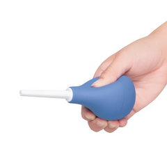 Side view of hand gripping blue silicone douche bulb showing ergonomic handheld fit