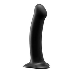 Side profile of black silicone Magnum dildo showing ergonomic curve and stable suction base