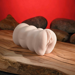 Side profile of compact ivory stroker showing ribbed exterior texture on wood surface