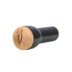 Side profile of stroker showing skin-tone sleeve seated in black cylindrical case on white background