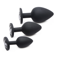 Side profile of three graduated black silicone anal plugs with flat decorative bases
