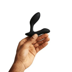 Side profile of We-Vibe Vector+ held in hand, highlighting curved dual-arm silicone design