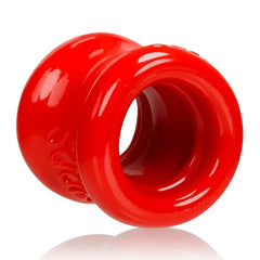 Side close-up of red Squeeze ball stretcher showing hourglass waist and smooth TPR texture
