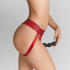 Side view of red Strap-On-Me Unique Harness showing adjustable side buckle strap and thigh band detail