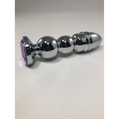 Side view of ribbed stainless steel anal plug featuring a faceted purple crystal base
