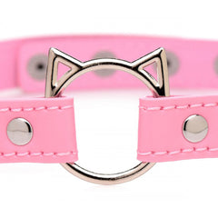 Close-up of silver cat-ear O-ring hardware on pink stitched faux-leather choker band with rivet detail