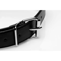 Close-up of the silver metal buckle on a black faux-leather adjustable strap