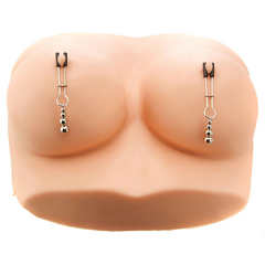 Silver nipple clamps with beaded pendants shown applied to a silicone breast form