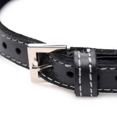 Close-up of silver pin buckle and white contrast stitching on black leather choker band