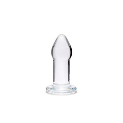 Single small clear glass anal plug standing upright, showing tapered tip and ridged base
