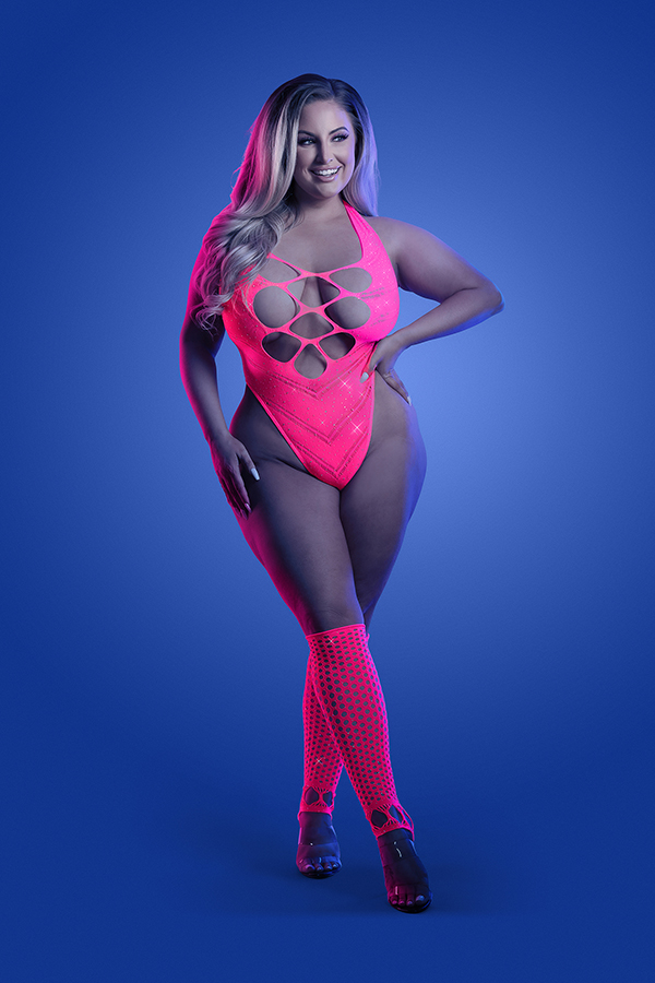 Plus-size model in neon pink Flashback rhinestone teddy paired with fishnet leg warmers and heels