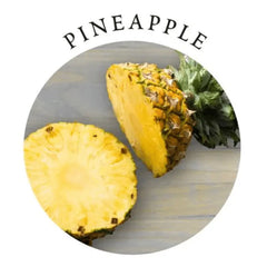 Sliced fresh pineapple on a wooden surface highlighting the Pineapple scent of this massage candle