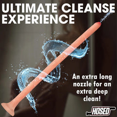 Slim silicone enema hose angled upward with water spray from tip, showing full length