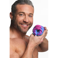 Smiling male model holding Cyclone stroker toward camera to show scale of the alien opening