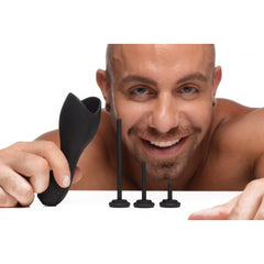 Smiling man holding black head teaser sleeve alongside three graduated urethral sound attachments