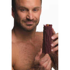 Smiling man holding lit red textured drip candle with ribbed thorn-pattern wax surface
