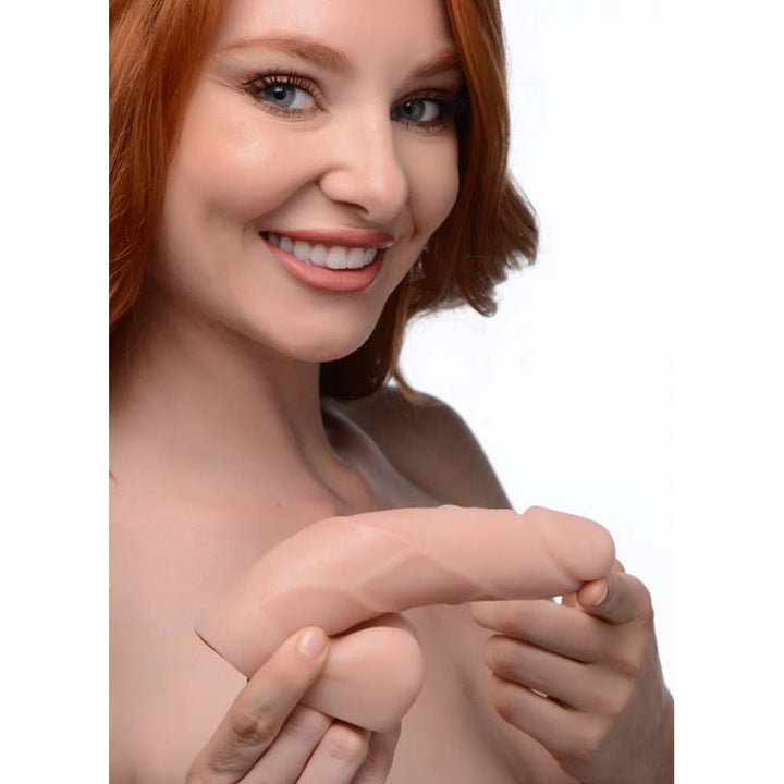 Smiling model holding the Strap U Large Bulge Packer Dildo in light skin tone